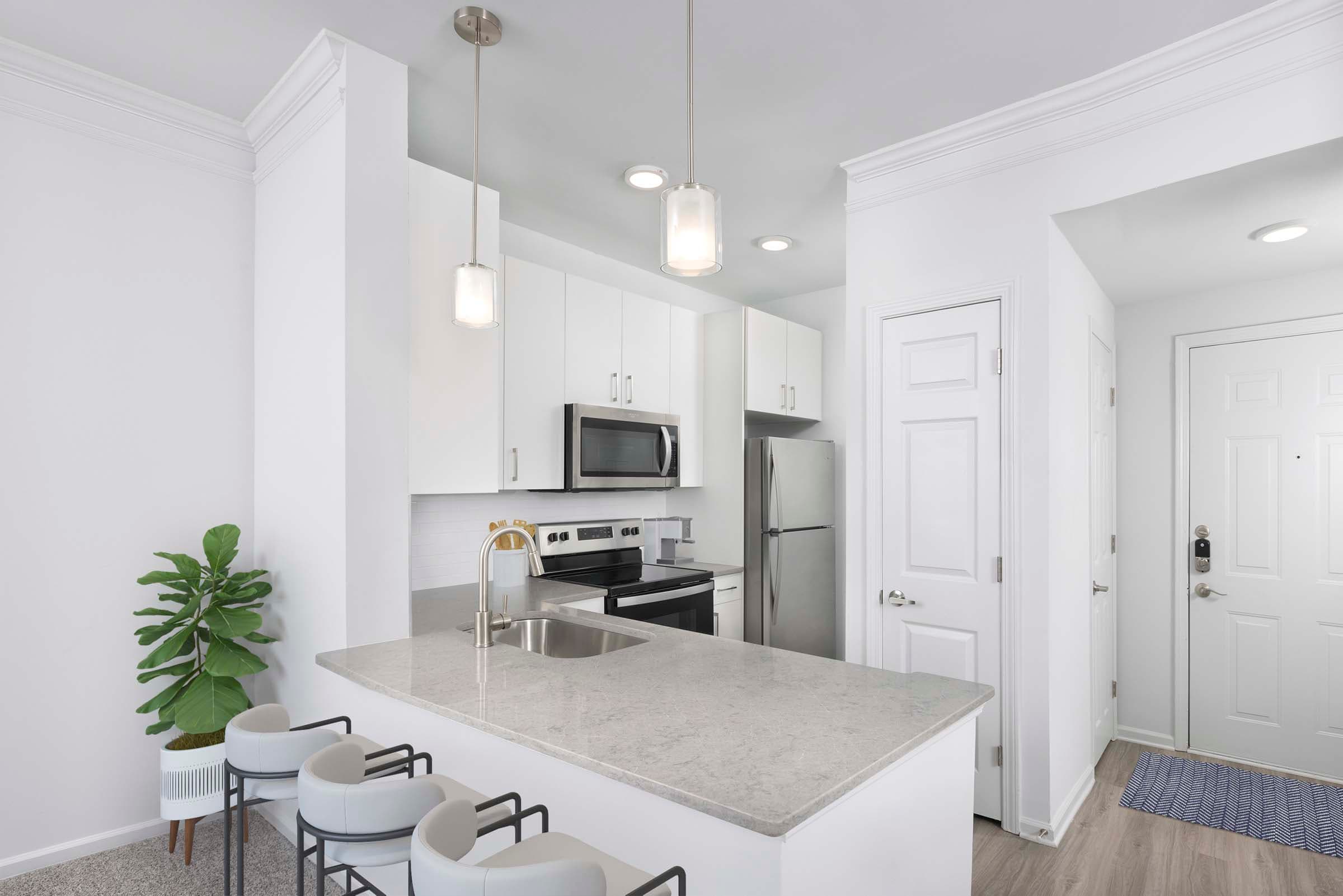 Renovated Kitchen with Modern White Cabinets and Gray Quartz Countertops