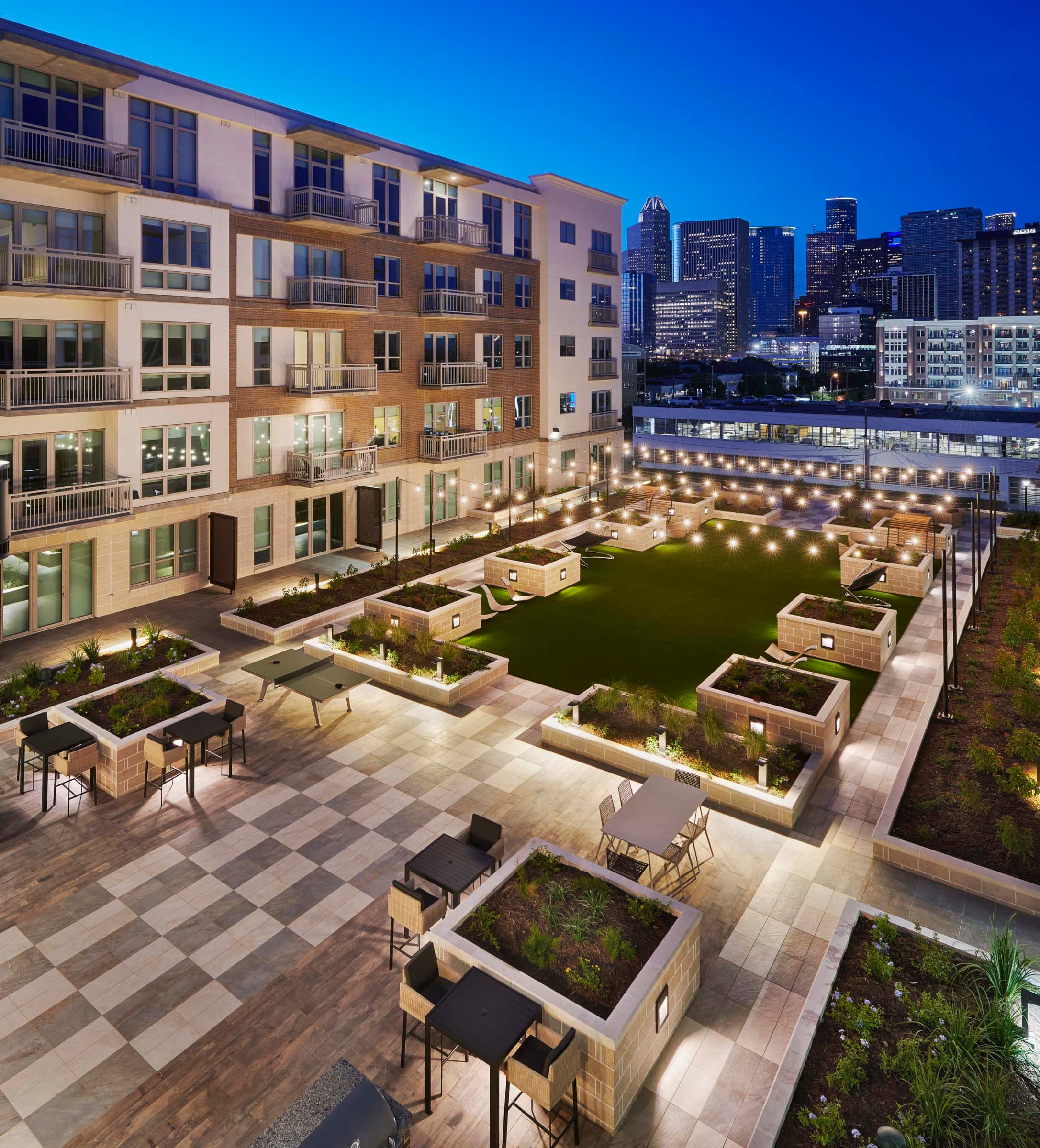 37-camden-mcgowen-station-apartments-midtown-houston-tx-outdoor-lounge-with-downtown-view-night