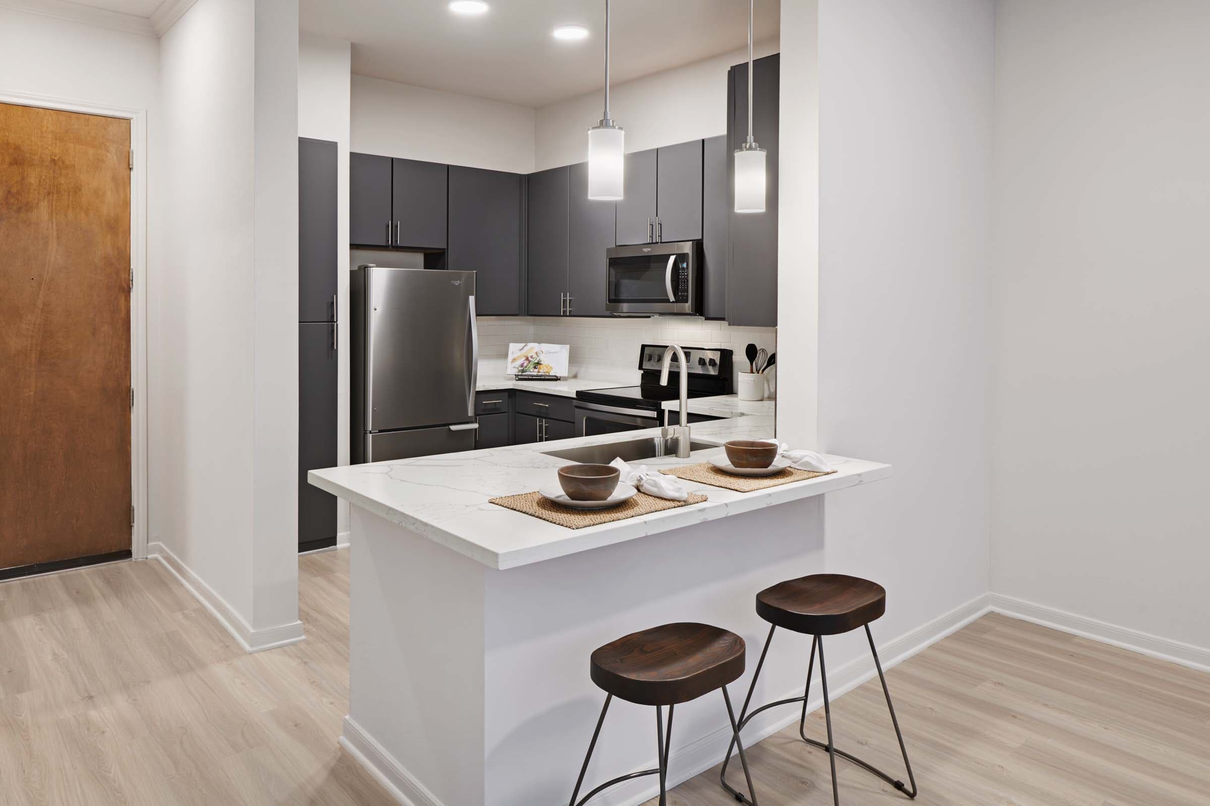 Modern Kitchens with Dark Gray Cabinets, White Quartz Countertops, and White Subway Tile Backsplash